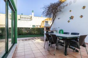 un patio con tavolo e sedie verdi di Acoteias do Alto A by Algarvemanta a Manta Rota