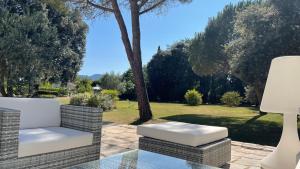 a patio with a white chair and a table at Chambre d'hôtes "le Parc" in Labruguière