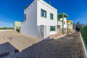 un edificio bianco su una strada di ciottoli di Acoteias do Alto A by Algarvemanta a Manta Rota