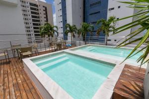 a swimming pool on the roof of a building at Manaíra Apart Flat in João Pessoa