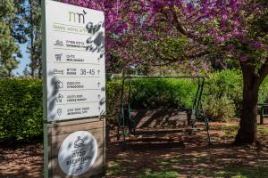 una señal frente a un parque con un banco en Kibbutz Malkiya Travel Hotel, en Malkiyya