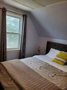 a bedroom with a large bed with a window at Rothesay Motel in Rothesay