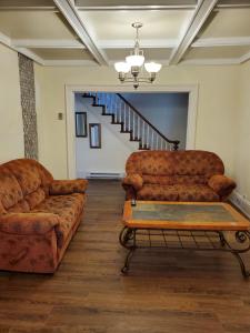 a living room with two couches and a table at Rothesay Motel in Rothesay
