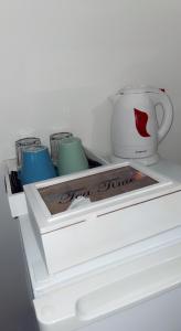 a white refrigerator with three cups and a coffee mug at Chambre cosy in Arles