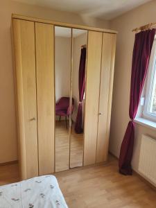 a bedroom with a wardrobe and a chair in it at Graz Liebenau in Graz