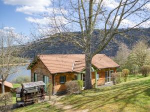 a log cabin on a hill with a tree at Vacancéole - Les Chalets de la Chazotte in Saint-Jacques-dʼAmbur