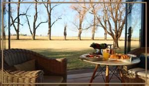 a table with a plate of food on a patio at Water on Waldrift Guesthouse in Vereeniging