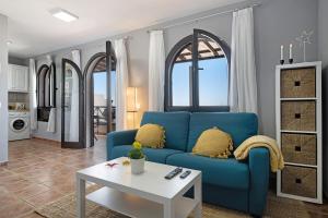 salon z niebieską kanapą i stołem w obiekcie Apartamento La Estrella ii w mieście Playa Blanca