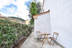 stół i dwa krzesła obok ściany w obiekcie Calaone Wondeful Duplex Apartment con parcheggio x4 w mieście Baone