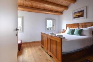 una camera con un grande letto con testiera in legno di Calaone Wondeful Duplex Apartment con parcheggio x4 a Baone