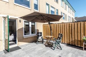 a patio with a table and two chairs and an umbrella at Studio Milis in Zandvoort