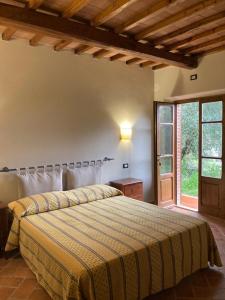 1 dormitorio con cama y ventana grande en Agriturismo La Vecchia Quercia, en Montemerano