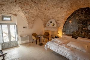 um quarto com uma cama grande e uma mesa em Ceglie Suites & Apartments - Celso em Ceglie Messapica