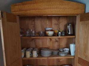 a wooden cabinet with plates and dishes on it at Relaxen im Taubertal in Niederstetten