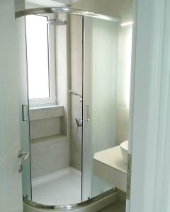 a shower with a glass door in a bathroom at Theasis Limnos - 1st floor suite in Agios Ioannis Kaspaka
