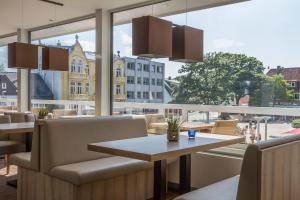 a restaurant with a table and chairs and a large window at Hotel Christiansen in Cuxhaven