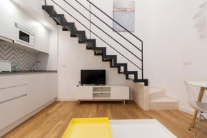 a living room with a staircase and a tv at El Duplex de Barrocal in Cádiz