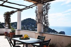 una mesa en un patio con vistas al océano en La Terrazza Apartment, en Capri