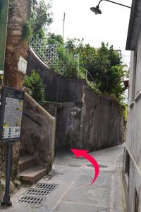 un callejón con una flecha roja apuntando a un edificio en La Terrazza Apartment, en Capri