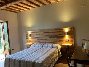 1 dormitorio con cama y cabecero de madera en Agriturismo La Vecchia Quercia, en Montemerano