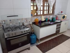 a kitchen with a stove and a sink at Chácara Ebenézer in Santa Isabel
