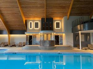 an indoor swimming pool with a fireplace in a building at Park Farm Hotel in Norwich