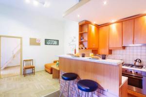 eine Küche mit Holzschränken und Hockern in einem Zimmer in der Unterkunft All in 10 apartment, BP downtown AC in Budapest