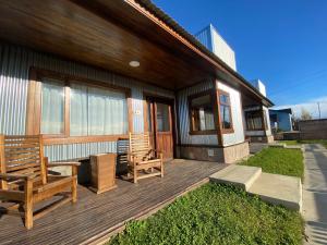 una terraza de madera con 2 bancos en una casa en Patagonia Austral Suites en El Calafate