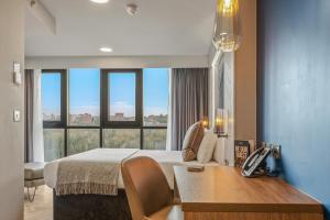 泰恩河畔新堡的住宿－紐卡斯爾市榕目茲酒店，酒店客房配有一张床、一张书桌和一部电话