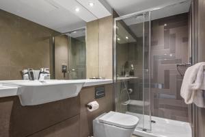 uma casa de banho com um lavatório, um WC e um chuveiro em Roomzzz Newcastle City em Newcastle upon Tyne