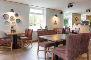 a dining room with wooden tables and chairs at Hotel Giethoorn in Giethoorn