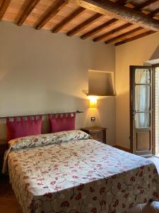 1 dormitorio con 1 cama con cabecero rojo en Agriturismo La Vecchia Quercia, en Montemerano