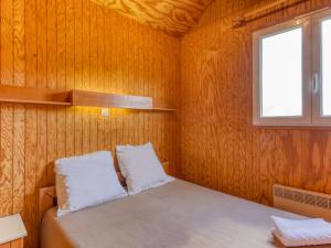 a small room with a bed and a window at Vacancéole - Les Chalets de la Chazotte in Saint-Jacques-dʼAmbur