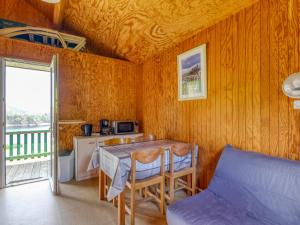 a room with a table and a bed and a kitchen at Vacancéole - Les Chalets de la Chazotte in Saint-Jacques-dʼAmbur