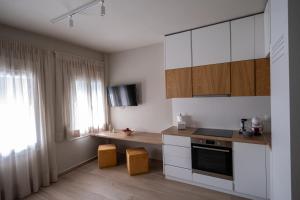 une cuisine avec des placards blancs et un comptoir dans l'établissement Elia Didotou City Apartments, à Athènes