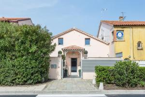 uma casa branca com um portão e uma torre de relógio em Maison d' Orange - Chambres em Saint-Tropez