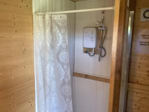 a bathroom with a shower curtain and a light at Vigo Retreat cabin 2 in Vigo Village