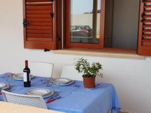 a table with a blue table cloth and a bottle of wine at Villa Melania ( Delfino BLU) in Lampedusa