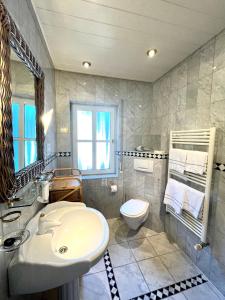 ein Badezimmer mit einem weißen Waschbecken und einem WC in der Unterkunft Schweizerhaus am Kurpark in Boppard