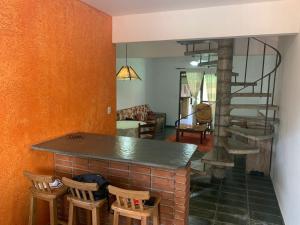 uma sala de estar com uma lareira de tijolos e uma escada em espiral em Cond Frente a Praia c/ Piscina - Boiçucanga em Boiçucanga