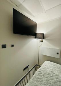 um quarto com uma cama e uma televisão na parede em Domek Zielone Centrum em Stronie Śląskie