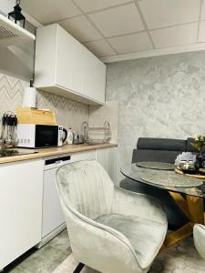 uma cozinha com uma mesa, uma cadeira e um micro-ondas em Domek Zielone Centrum em Stronie Śląskie