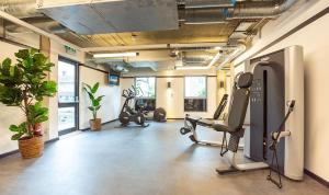 a gym with treadmills and exercise equipment in a room at Modern and Stylish Studio Apartments at Westcombe House in Greenwich in London