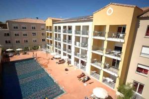 an apartment complex with a swimming pool in a courtyard at Superbe appartement au porte de Montpellier in Juvignac