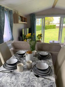 einen Tisch mit Tellern und Tassen darüber in der Unterkunft Skegness,North shore holiday park , new 8 berth caravan for rent in Skegness