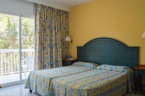a bedroom with a bed and a large window at Es Pi 2 in Playa Migjorn