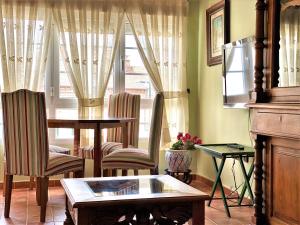 d'un salon avec une table, des chaises et une fenêtre. dans l'établissement Housing León Marigold, à León