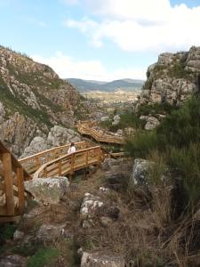 a man walking on a wooden bridge on a mountain at vivenda do Sobreiro AL in Serpins +18 photos