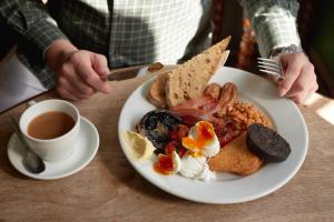 a plate of breakfast food on a table with a cup of coffee at The Bell & Crown in Zeals