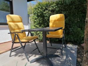 two yellow chairs sitting next to a table at Apartment Lieblingsort in Kreuzwertheim